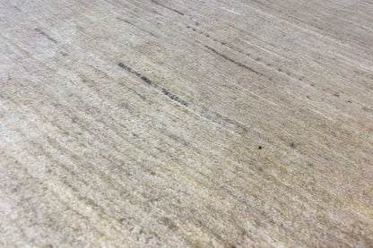 Surface of a light beige Gabbeh rug with fine, parallel lines