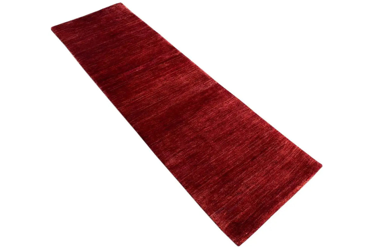 Reddish-brown Gabbeh runner, positioned at an angle, mottled surface