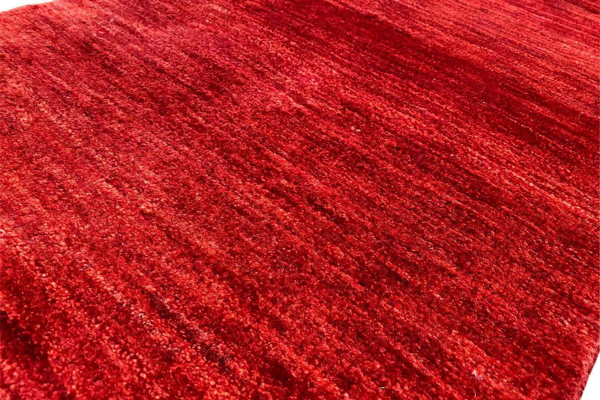 Close-up of the carpet surface: vivid red, mottled fibers