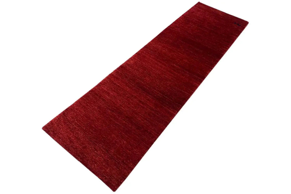 Gabbeh runner rug, red mottled pile with a fine linear texture