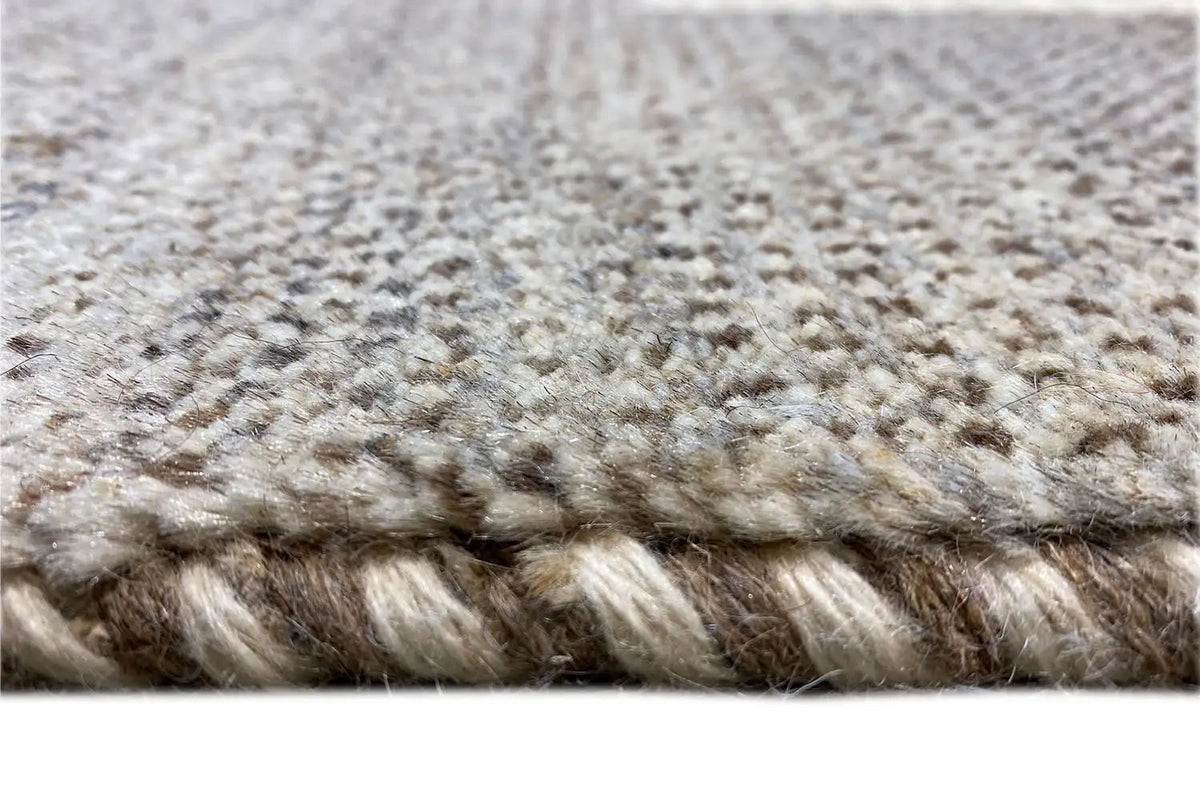 Carpet pile in close-up: mottled beige-gray fibers, short dense texture