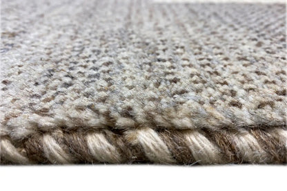 Carpet pile in close-up: mottled beige-gray fibers, short dense texture