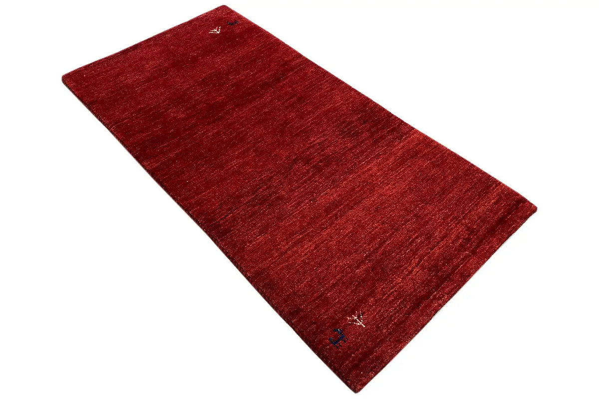 Gabbeh rug in deep red, laid diagonally, with small white ornaments
