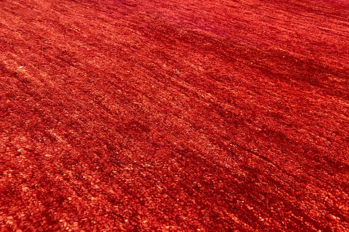 Close-up of red carpet pile with a fine, patterned texture