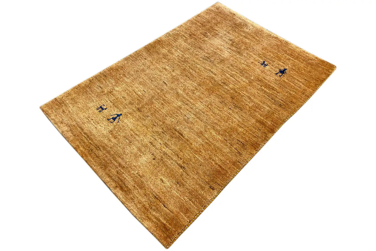 Gabbeh rug 122x78 cm, honey brown with blue motifs, diagonal view
