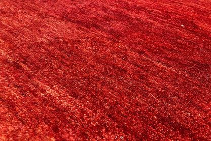 Gabbeh rug, red pile with a dense, fine texture in close-up detail, 110x73 cm.
