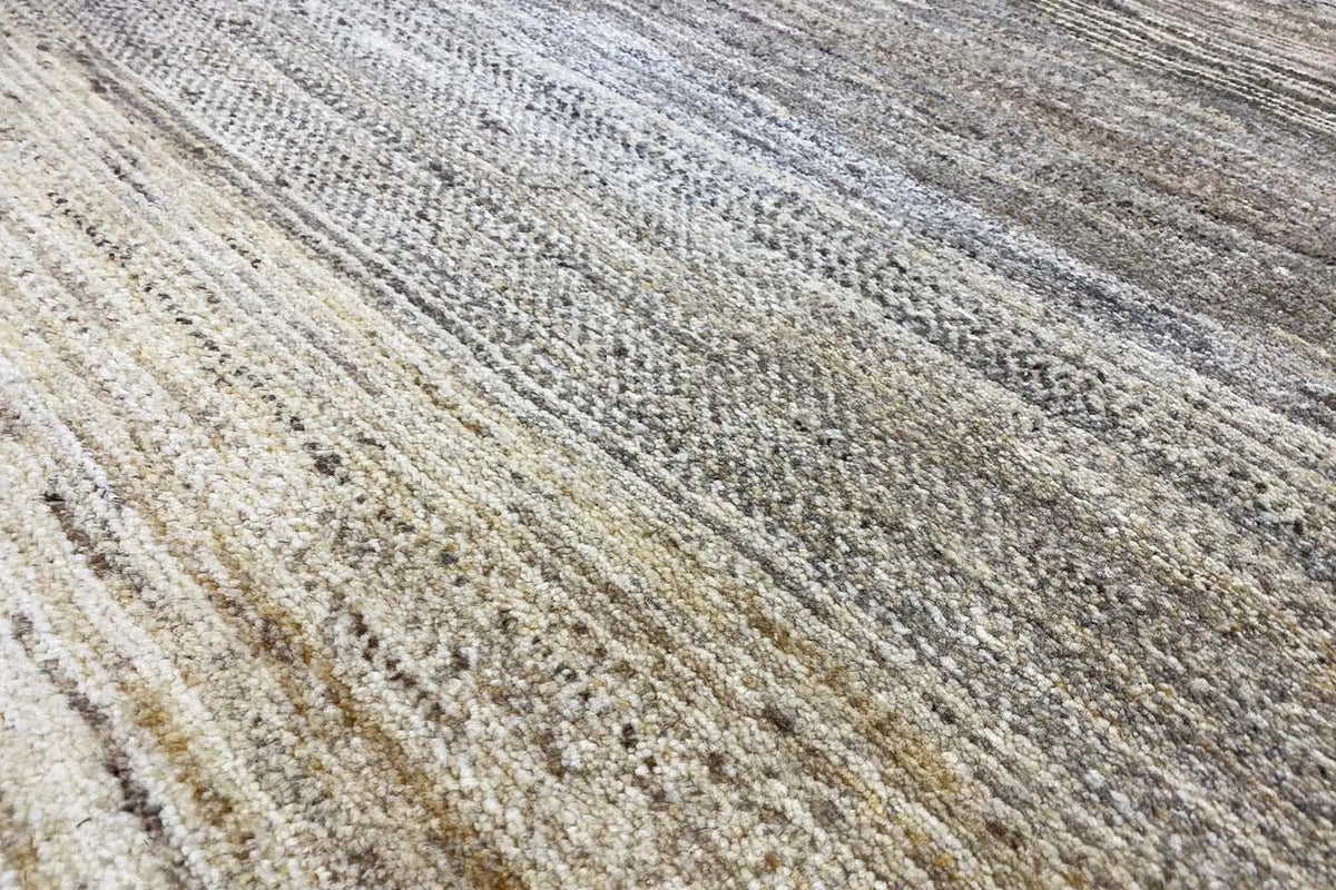 Close-up of a Gabbeh rug: striped pattern in beige, gray, and brown