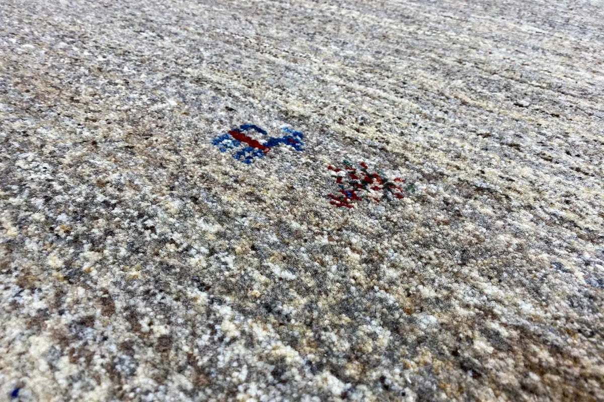 Detail view: Gabbeh rug with light beige-gray and red/blue cross pattern