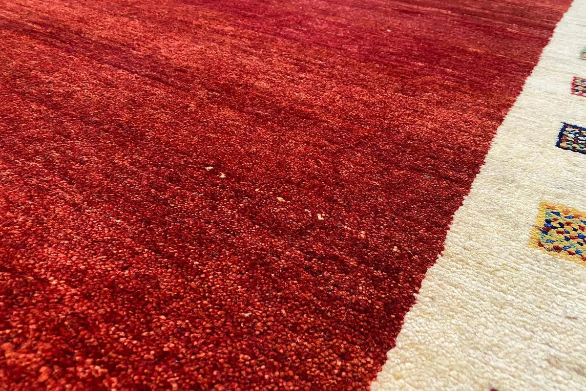 Red carpet section with a fine texture and a beige border featuring ornaments