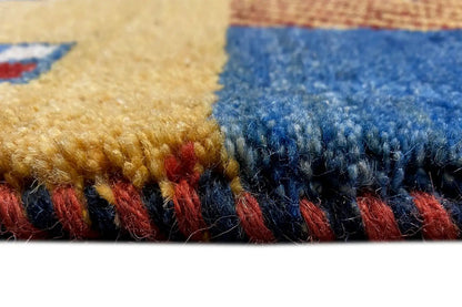 Close-up of Gabbeh rug: pile and color transition at the edge with blue and red zones