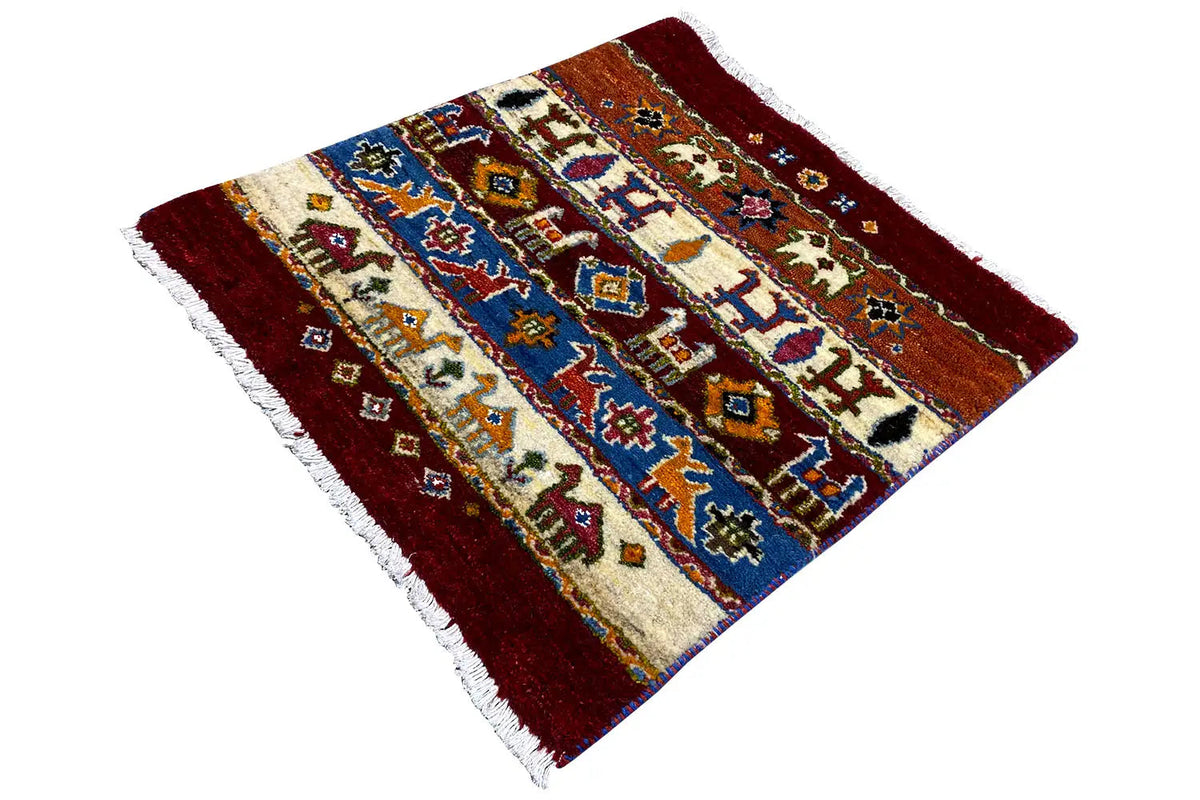 Gabbeh Lori rug, diagonal view, burgundy, blue and cream with figurative patterns, fringes