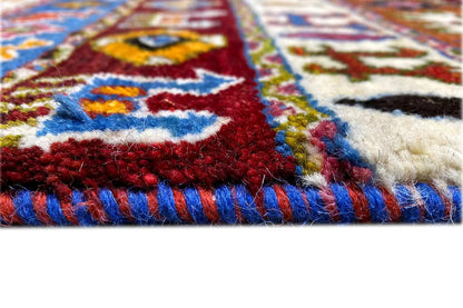 Carpet edge with burgundy pile, colorful ornamental stripes, and white fringes