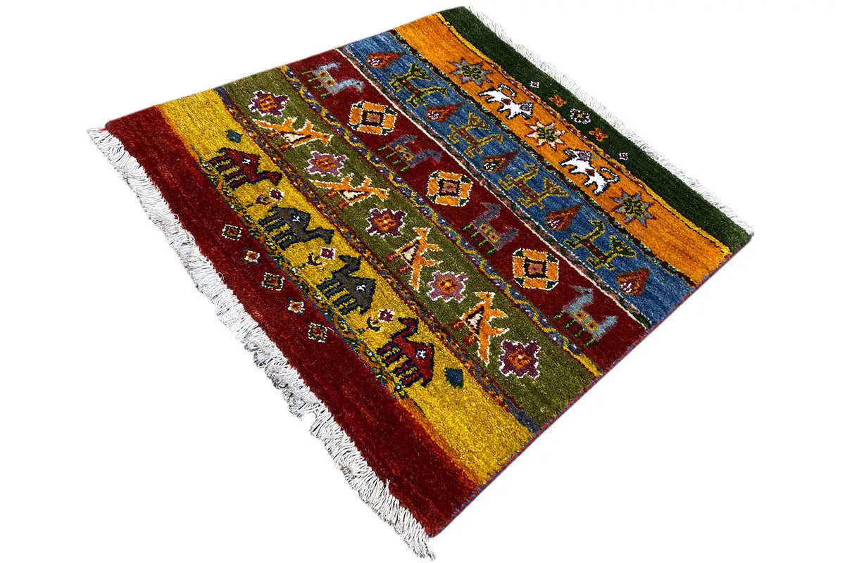 Gabbeh rug with decorative motifs in green, blue, and red, fringes