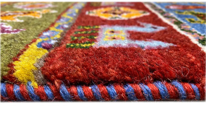 Close-up of the Gabbeh rug: dense pile, colorful border, and fringe