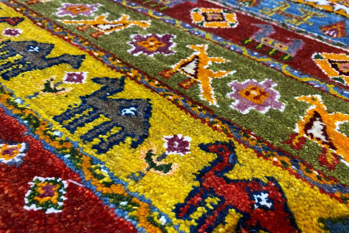 Close-up: Gabbeh rug with colorful tile motifs and ornaments, yellow base tone