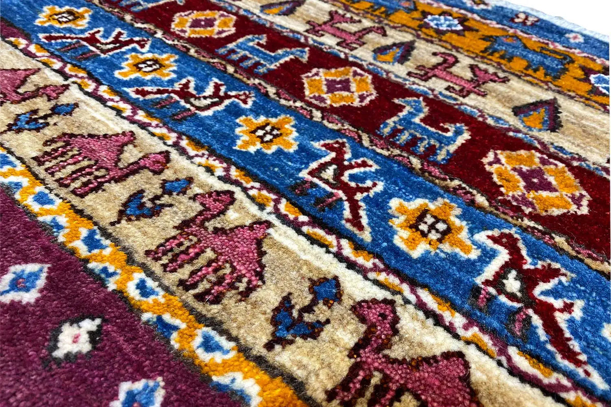 Close-up of a Gabbeh Lori rug: colorful ornaments and medallions in blue, red, and beige