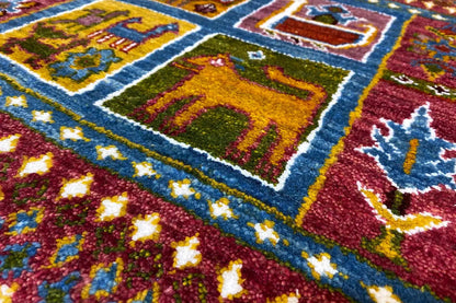 Gabbeh-Lori rug detail: colorful embroidered patterns on a reddish-brown pile with a blue border
