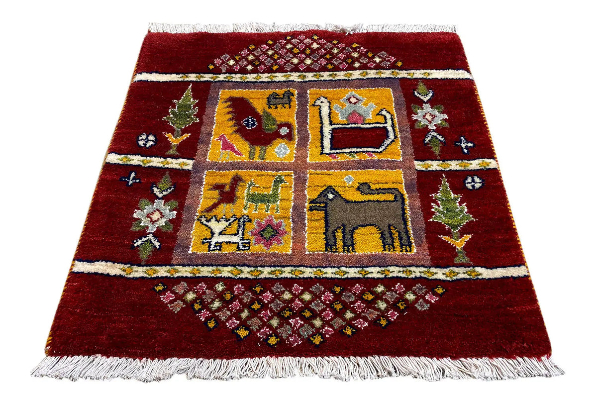 Gabbeh Lori rug with a red background, multicolored medallions, and a white fringed border