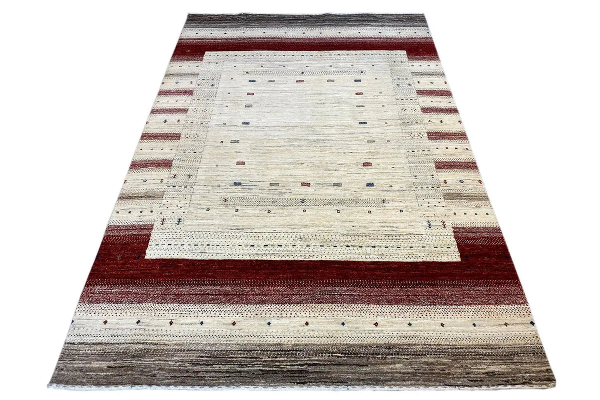 Gabbeh rug laid flat: cream, reddish-brown, and gray stripes in the layout