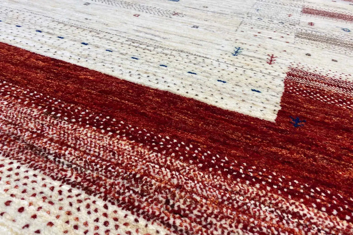 Gabbeh rug detail: red-brown field with a fine speckled texture and woven-in dots