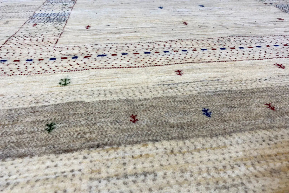 Gabbeh rug close-up: fine texture, cream-colored base with multicolored decorative dots