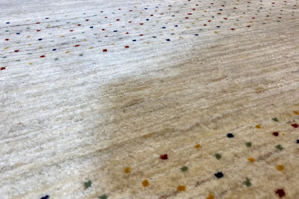 Gabbeh rug, close-up view with beige pile and small colorful dots