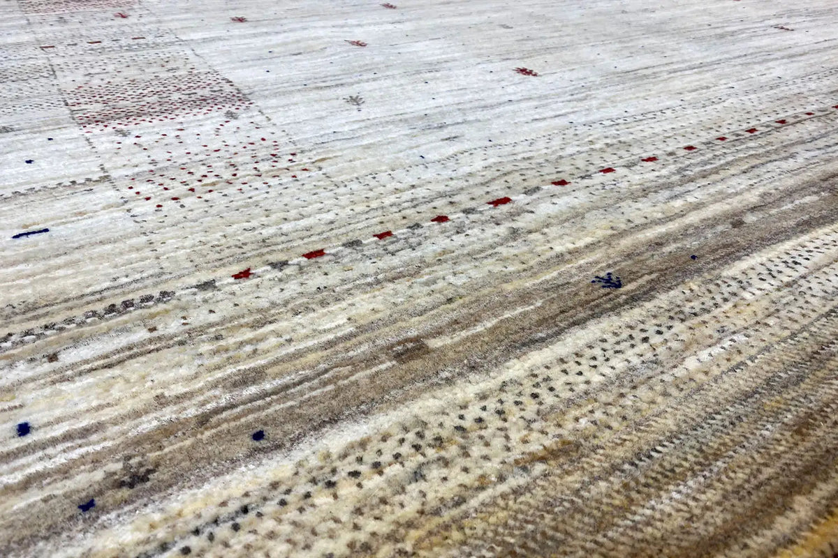 Gabbeh rug detail: beige background with stripes and colorful speckles