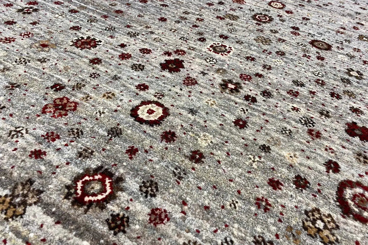 Close-up of a Gabbeh Lori rug: gray-brown pile with brown and dark red ornaments