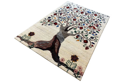 Gabbeh rug spread out rectangularly, with a tree crown and floral motifs in multicolored hues