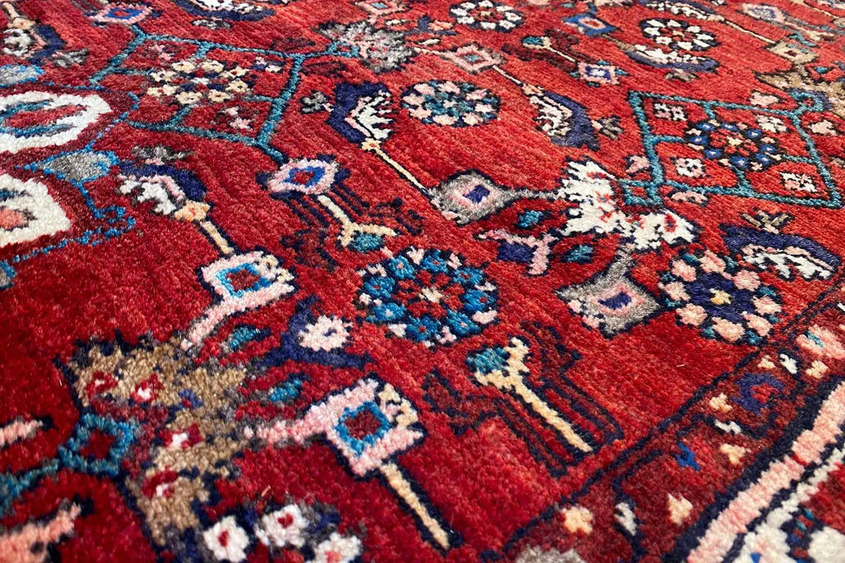 Hamadan runner close-up: red carpet surface with blue and cream-colored ornaments