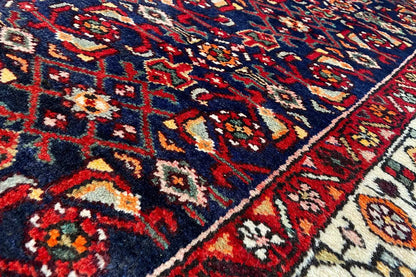 Close-up of the oriental rug runner: dense pile, colorful geometric pattern in blue and red.