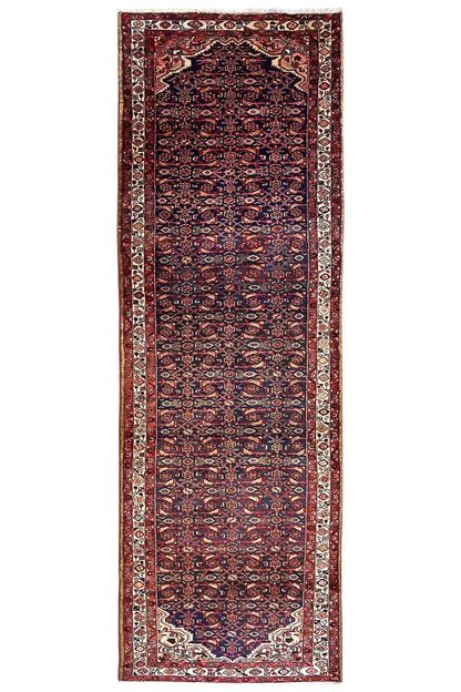 Portrait-oriented Oriental rug runner with a dark red and blue pattern and a border all around.