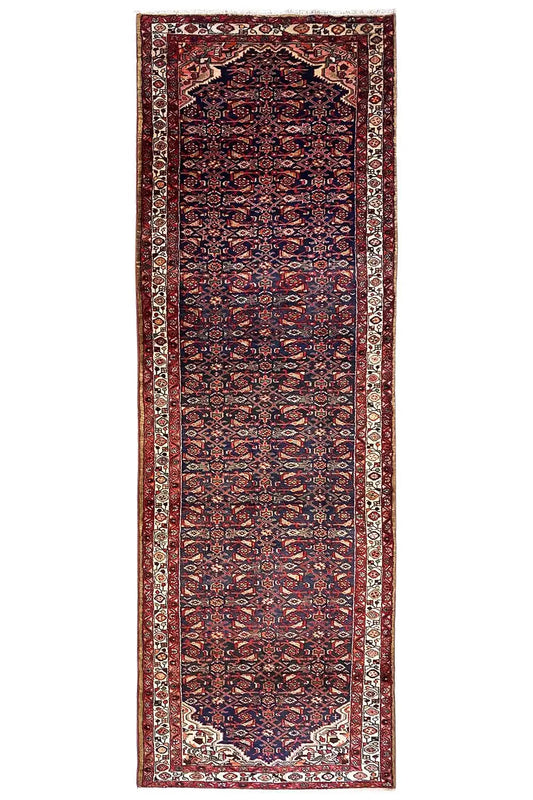 Portrait-oriented Oriental rug runner with a dark red and blue pattern and a border all around.