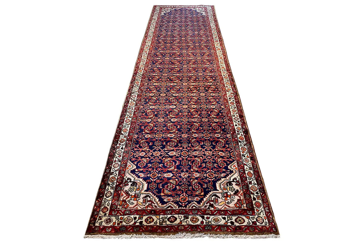 Oriental rug runner, upright view: blue-red ornamented row with a wide border