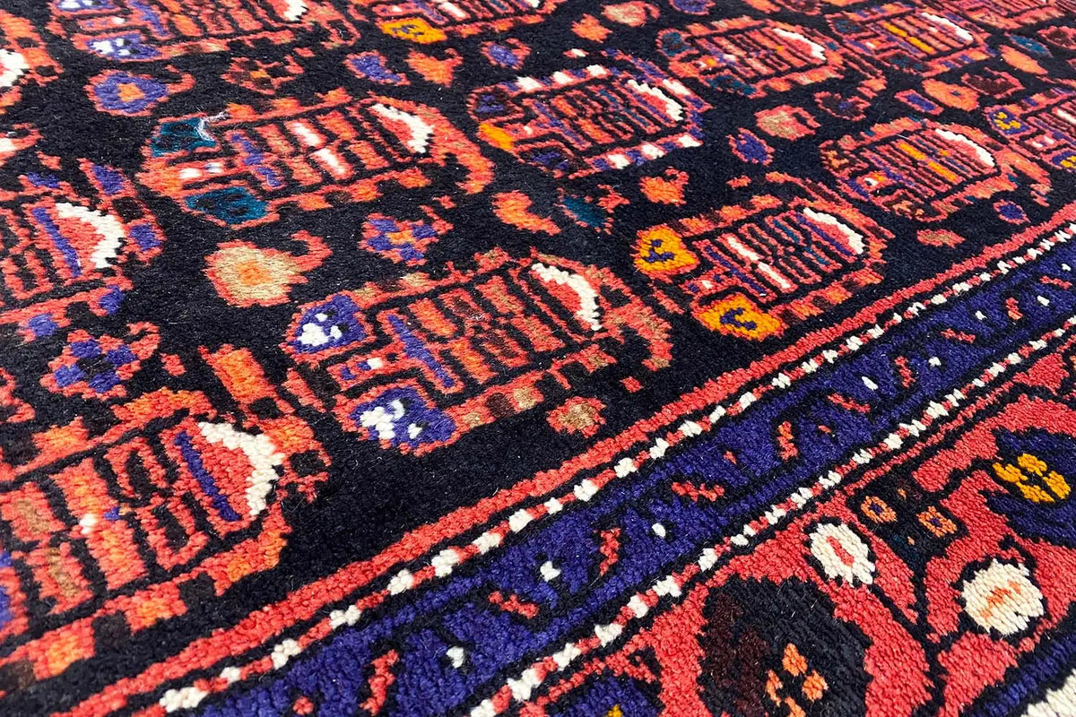 Close-up of the Hamadan runner: dense ornamental print in dark blue, red and beige