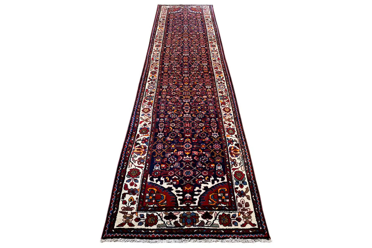 Long runner rug with a dark red background, central medallion pattern, and decorative borders