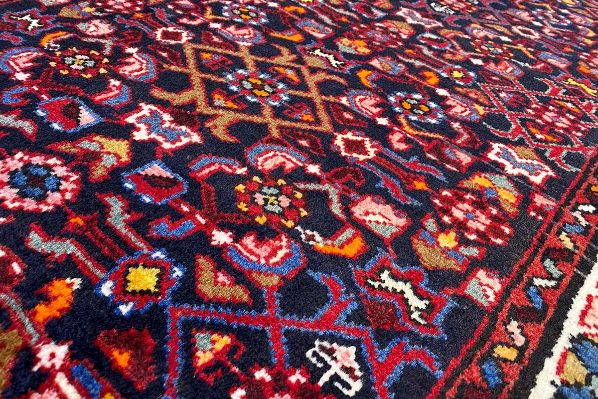 Close-up: rug pile with a colorful mix of red, blue, yellow, and white ornaments