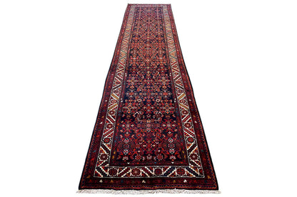 Dark patterned oriental rug runner shown at an angle, with a border and fringes