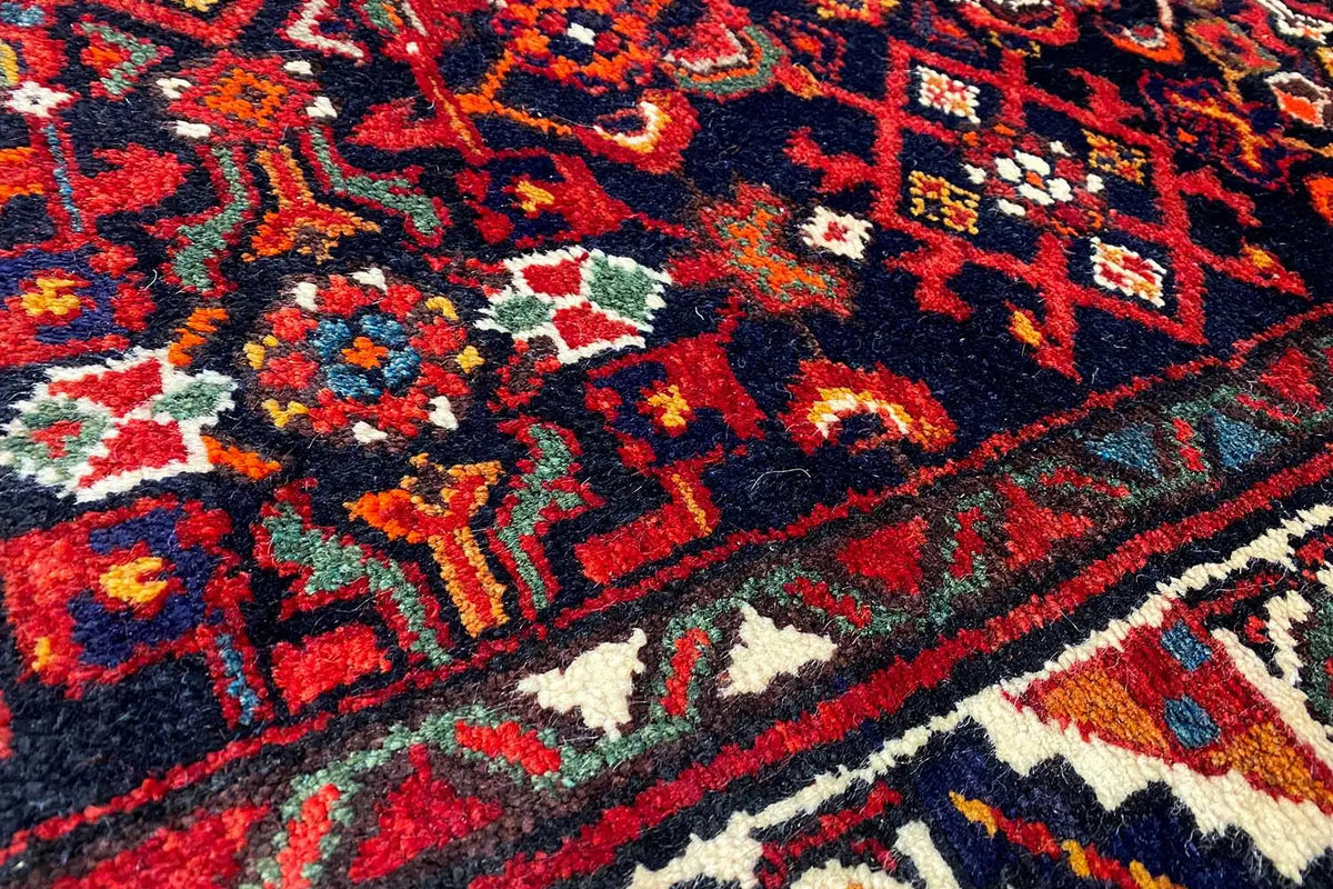 Detail of the Oriental rug pattern: dark red, blue, yellow, and white ornaments