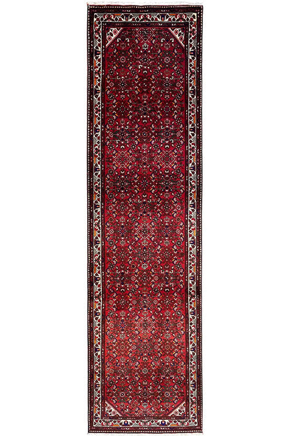 Narrow red runner with a framed border, central ornamental panel, and outlined corners