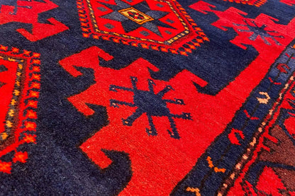 Close-up of red motifs on a dark blue background with zigzag and star patterns.