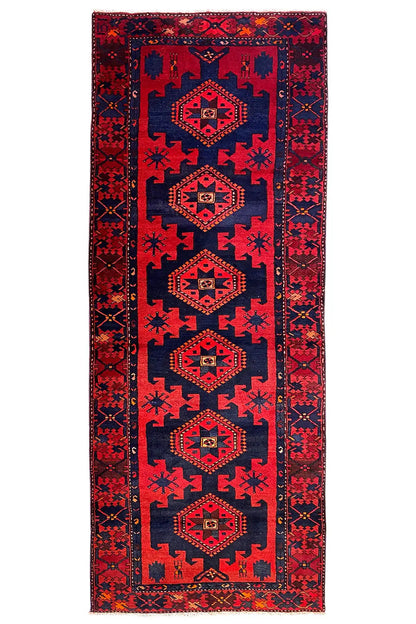 Knotted runner rug in red and dark blue with several medallions in the vertical border band.