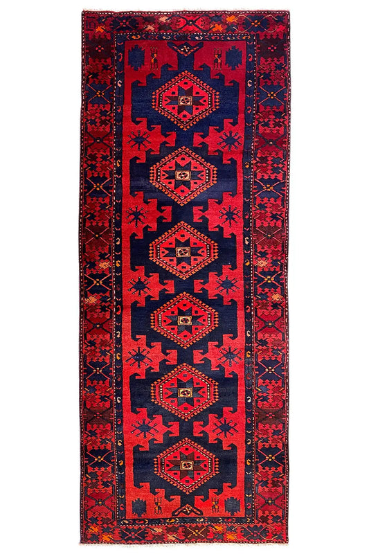 Knotted runner rug in red and dark blue with several medallions in the vertical border band.
