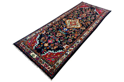Oriental rug runner viewed at an angle, dark background with colorful ornaments