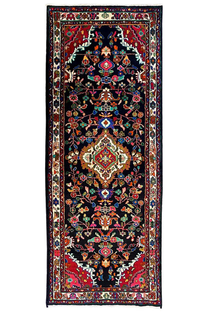 Oriental runner rug with a dark background and floral medallions, bordered