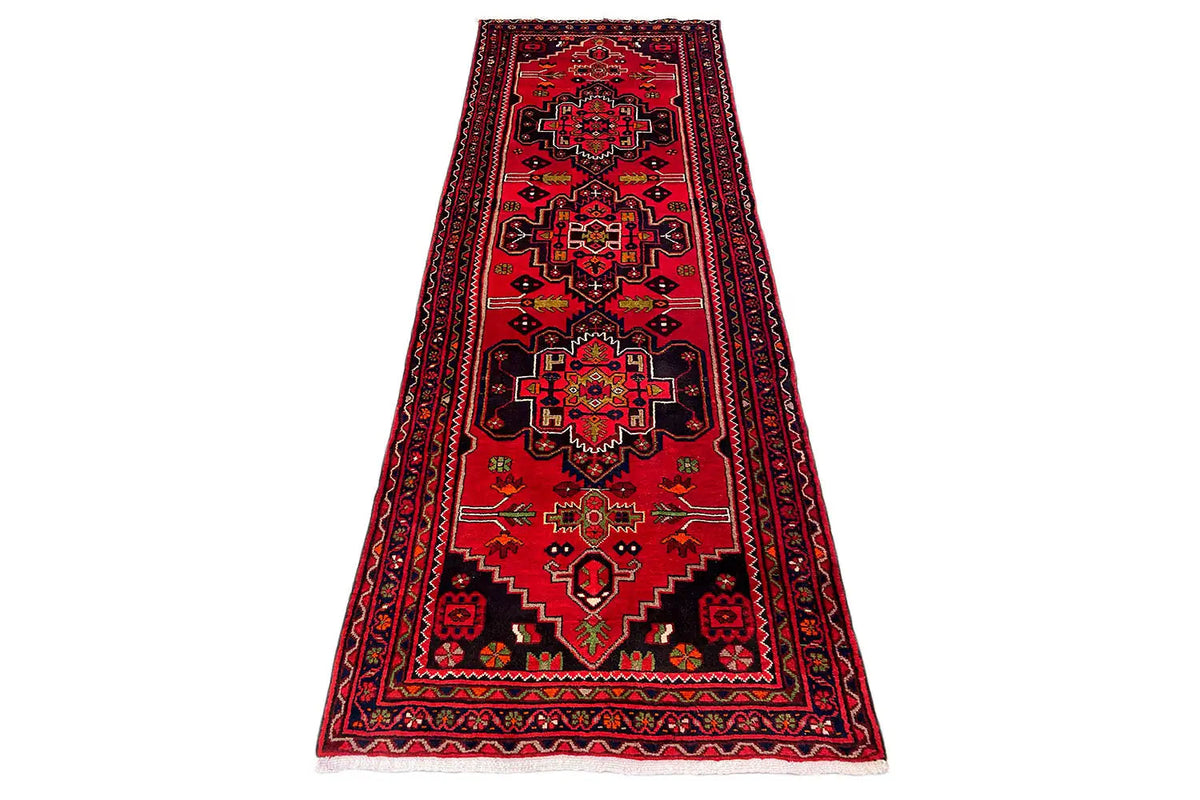 Hamadan runner with a red central medallion and geometric ornaments, lying diagonally