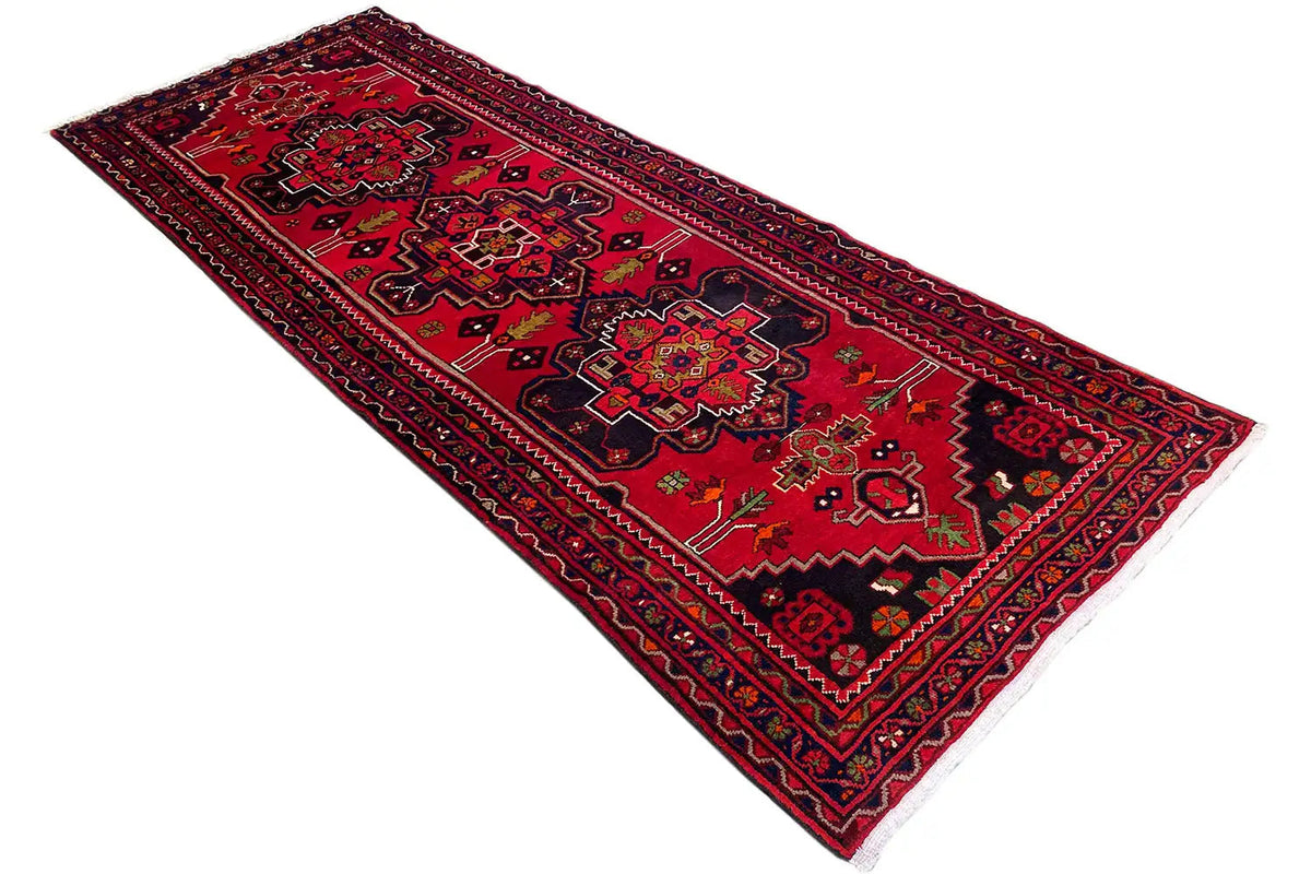 Hamadan runner with a red field, dark border, and central medallions, diagonal