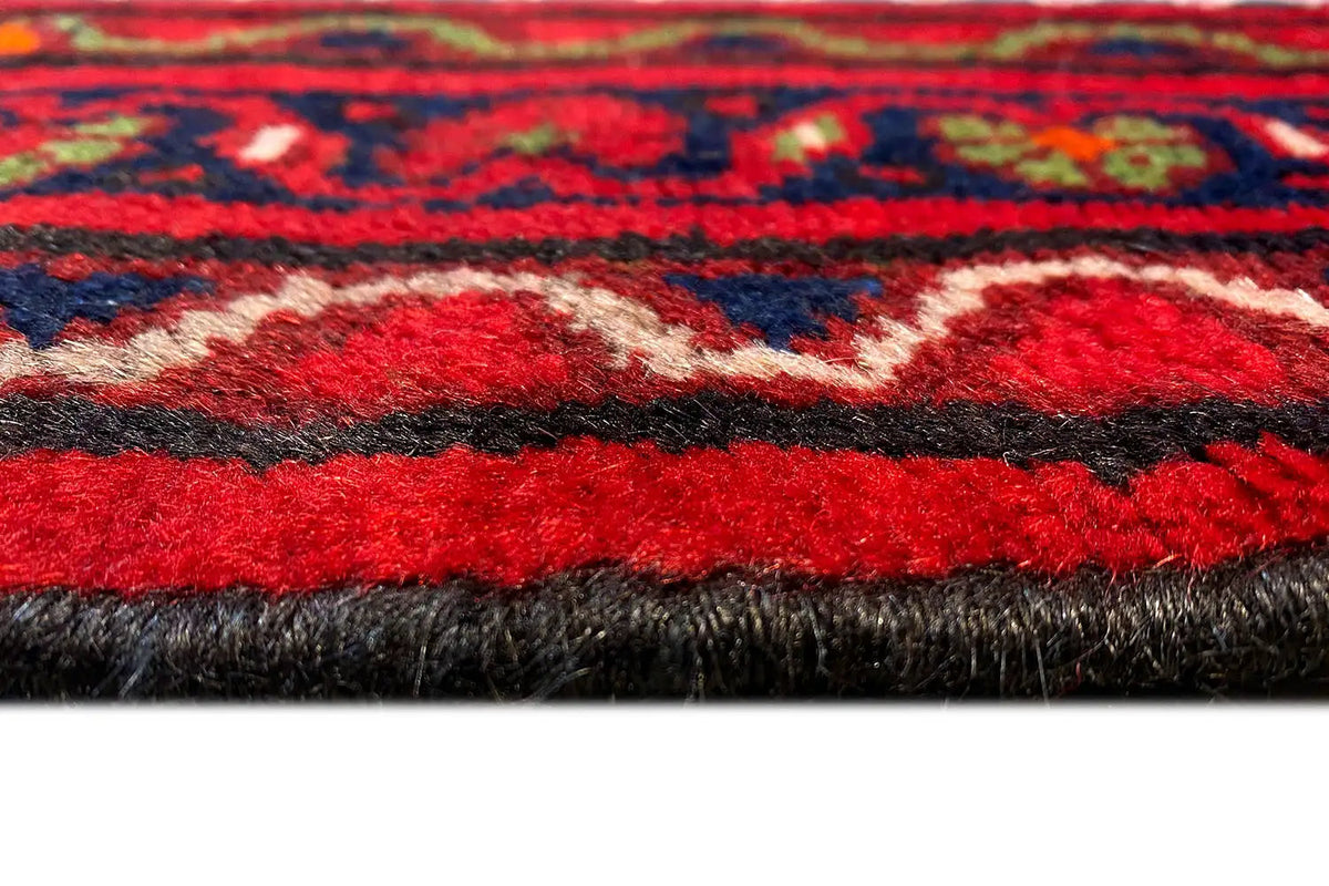Close-up: Hamadan runner, red pile surface with a multicolored patterned border
