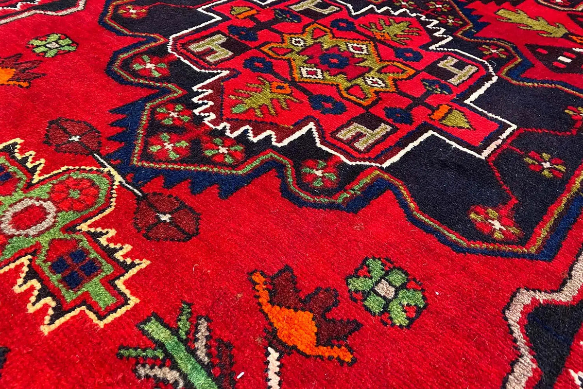 Close-up: Hamadan rug, dense red pile with colorful geometric ornaments