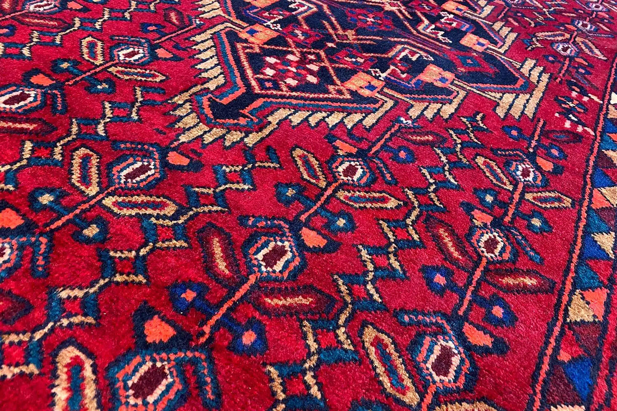 Detail of a Hamadan runner: red ornamental pattern with blue and beige accents